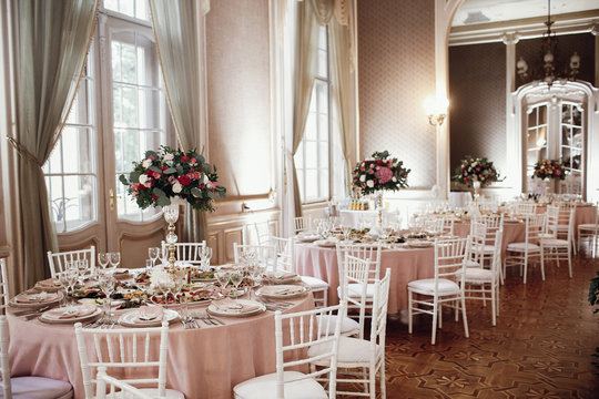 Wedding dinner table setting. Pink flowers and decor details on festive served tables