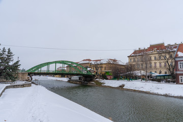 an old green bridge on a lake in the city center