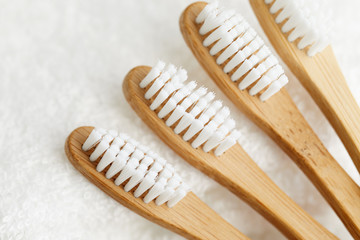 Close up of four bamboo toothbrushes on white towel