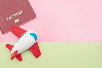 toy plane and passport on colorful copy space background. travel concept