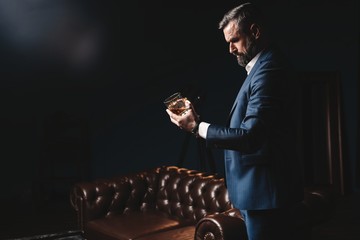 Degustation, tasting. Man with beard holds glass of brandy. Tasting and degustation concept....