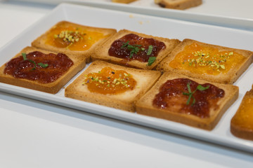 Biscuits with Various Jams served on a White Plate