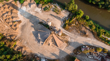 aerial view of sand factory with trees around and rusty metal. Image by drone in Bulgaria