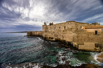Fototapeta na wymiar Middle Aged Maniace Castle on seacoast in island of Ortigia on Sicily, Siracusa.