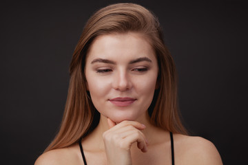 Fototapeta premium Young beautiful woman against dark background