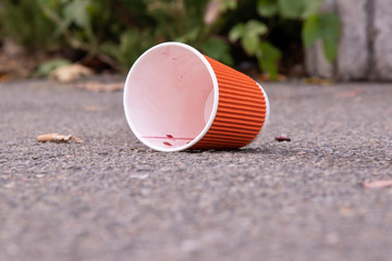 An empty glass under the drink lies in the middle of the street pollution concept of purity