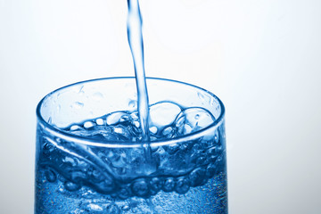 Fresh drinking water  is poured in a glass.  Bubbles in water. Close up.