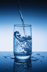 Fresh drinking water is poured in a glass. Bubbles in water. Close up.