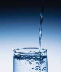 Fresh drinking water is poured in a glass. Close up.  Bubbles in water.