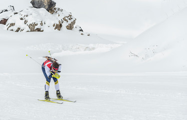 Winter sports. A participant in a biathlon competition, in a winter season in Spain, in a snowy landscape.