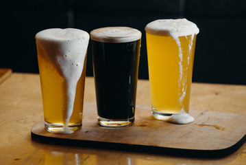 Glasses of light and dark beer in a pub. Dark background.