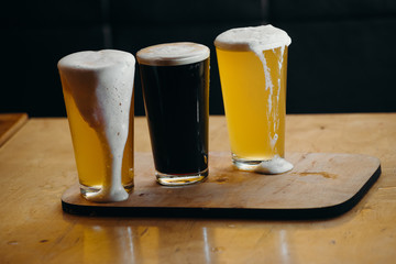 Glasses of light and dark beer in a pub. Dark background.