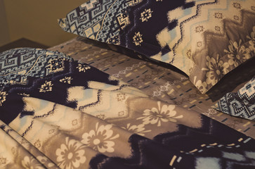 Blue bedding sheet, blanket and pillows in the hotel room. Rest, sleeping, comfort concept. Pillow on the bed. Image of comfortable pillows and bed. Stylish bedroom interior design.