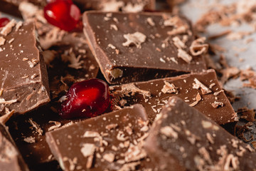 Broken chocolate pieces and chocolate powder, chocolate with hazelnut, chocolate and red...