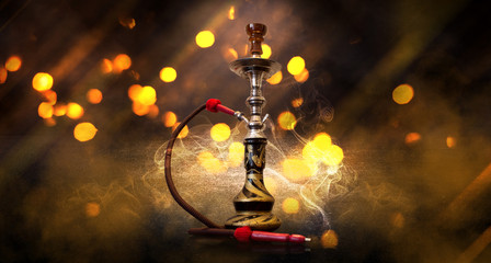 Hookah smoking on the background of a concrete floor, multi-colored blurred bokeh of the night city. Neon light smoke