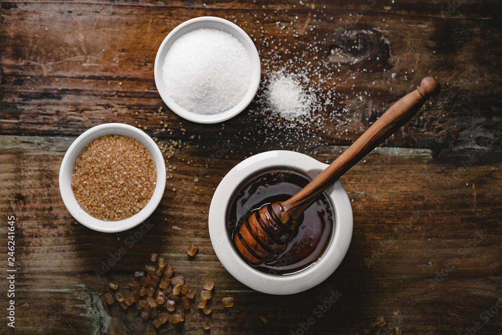 Wall mural different kinds of sugar and maple syrup on a background