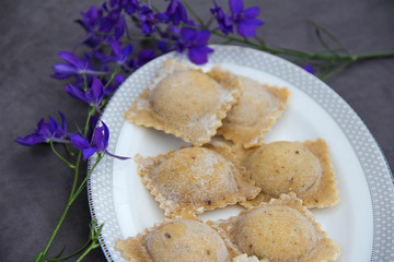 Raw ravioli with mushrooms on white plate