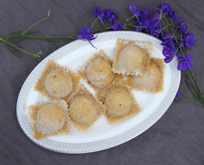 Raw ravioli with mushrooms on white plate