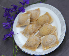 Raw ravioli with mushrooms on white plate