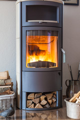Brennender Kamin im Großformat mit Kaminholz