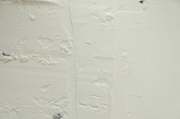 Texture of white flour on a dark wooden background.