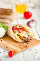 Wrap kebab with ingredients on wood table