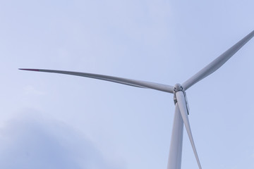 One windmill turbine top at blue cloudy sunset sky
