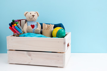 Wooden box with donations: children's toys, stationery and children's clothing. Concept: you can...