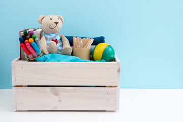 Wooden box with donations: children's toys, stationery and children's clothing. Concept: you can...