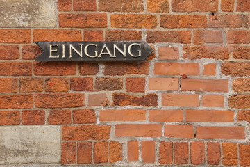 Fototapeta na wymiar German entrance inscription on a brick wall