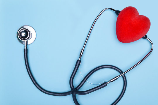 Medicine and healthcare.Listen to the heart with statoscope.Closeup of a heart and a statoscope on a blue background, top view.