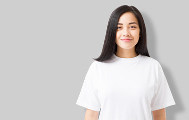 Asian girl in blank template t shirt isolated on gray background. Young woman in tshirt copy space...