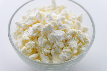 Cottage cheese very useful dairy product for the development of the child's body. Plate with curd on a white background.