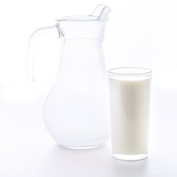 Fresh milk in a glass poured from a jug. A cup of milk in the morning for breakfast is very useful for health.