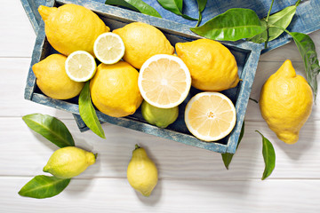 Fresh  organic lemon fruits with leaves on wooden table. Healthy food concept. Vitamin C - obrazy, fototapety, plakaty