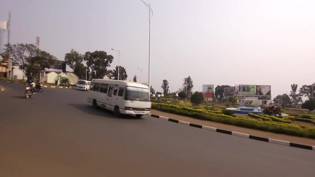 Traffic circle, roundabout with cars, motorbikes, motorcycles, bus, buses driving on a road in Kigali, Rwanda 