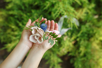 Florist decorator hold bracelet for bridesmaid made from fresh pink rose. Wedding flowers decoration