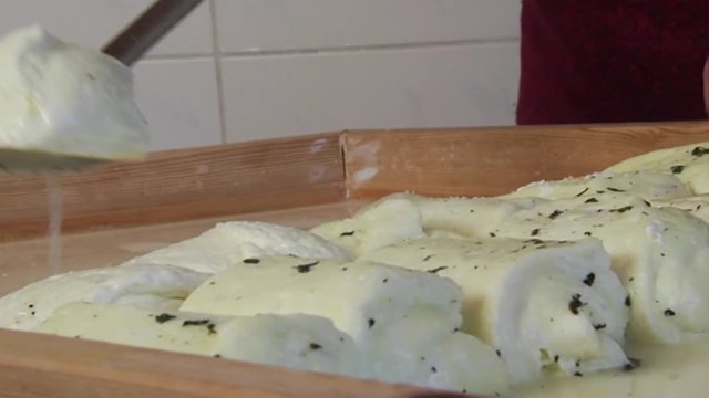 Close-up of making traditional halloumi Cyprus cheese as it is removed from brine and layer out