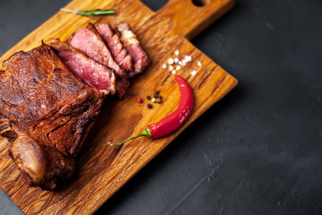 delicious steak, seasonings, a delicious piece of meat, cooked dinner on a concrete background