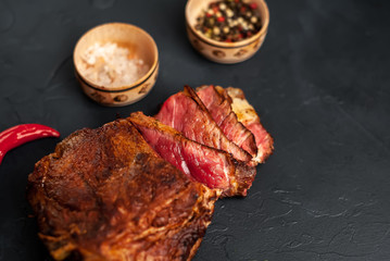 delicious steak, seasonings, a delicious piece of meat, cooked dinner on a concrete background