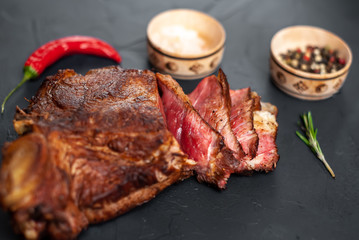delicious steak, seasonings, a delicious piece of meat, cooked dinner on a concrete background