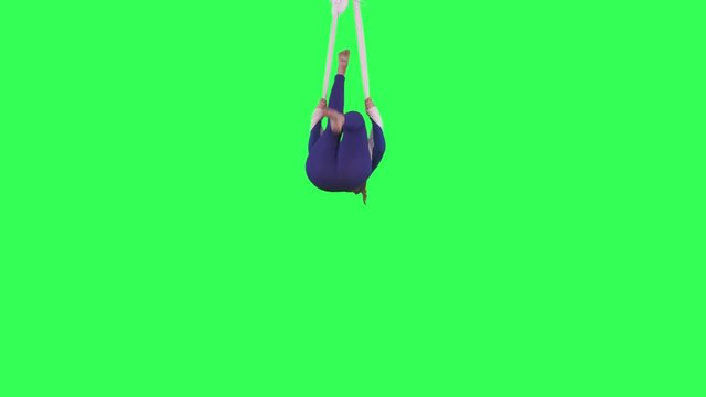 Acrobatic Tissue Artist performs wearing a blue suit over a green screen