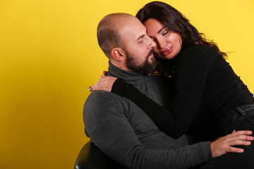 young sexy couple models in hugs in love smile and happy on yellow background , isolated on yellow , love ,couple 