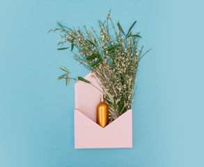 Golden bottle with herbs and flowers © Simonforstock
