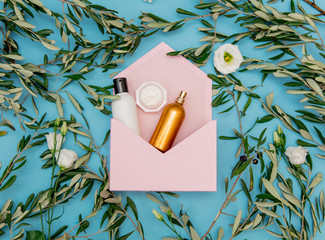 Cream and bottle in pink envelope with olive