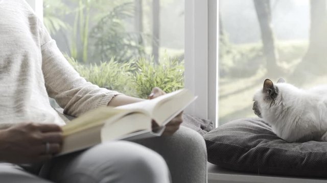 Woman relaxing in the living room with her cute cat