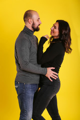 Full light portrait of young sexy model couple on yellow background 
