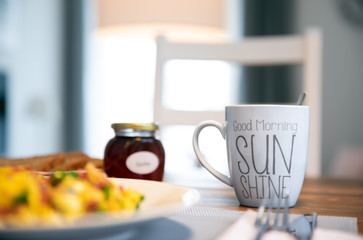 Fototapeta na wymiar Am Morgen gedeckter Frühstückstisch mit frischen Rüheiern, Schinken und Kaffee in der Küche zubereitet