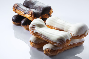 French dessert Eclair with white and black chocolate on white background. Closeup. Selective focus....