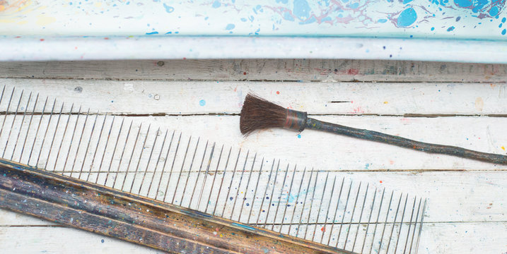 Brushes for drawing technology ebru lie on a white wooden table